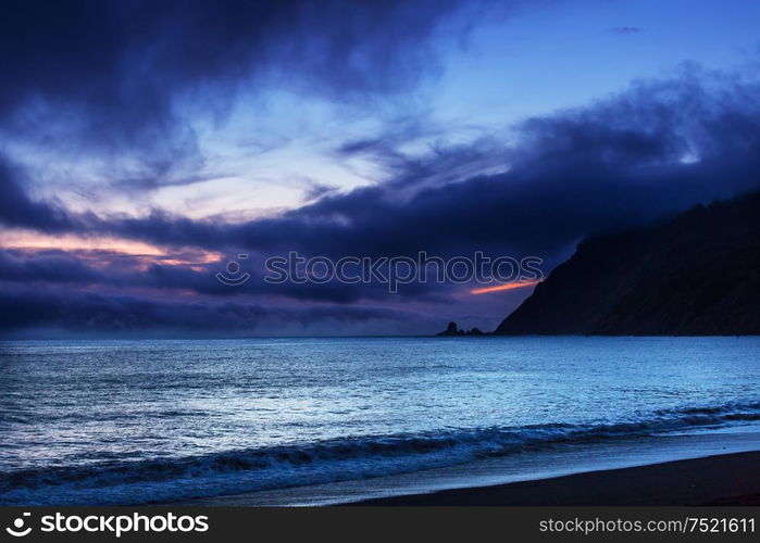 rain weather above ocean at sunset