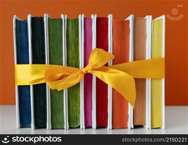 rainbow books stack with yellow ribbon