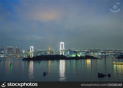 Rainbow bridge in twilight at odaiba Japan. struction bridge over river.