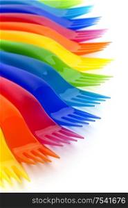 Rainbow colored plastic forks on white background