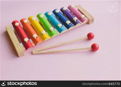 Rainbow Colored Wooden Toy Xylophone on pink bacground. Glockenspiel toy made of metal and wood. Rainbow Colored Wooden Toy Xylophone on pink bacground. toy glockenspiel made of metal and wood