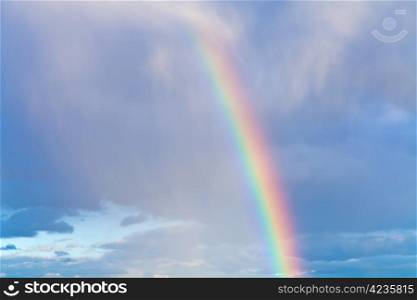 rainbow in autumn blue cloudy sky