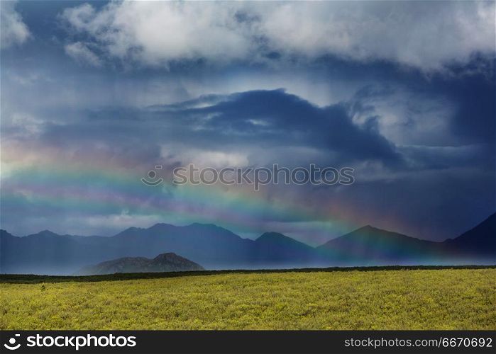 Rainbow in mountains. Rainbow above mountains, Alaska