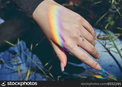 Rainbow light in a female hand