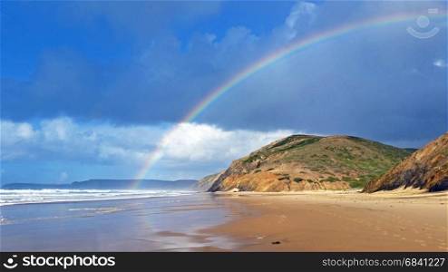 Rainbow on Vale Figueiras beach in Portugal