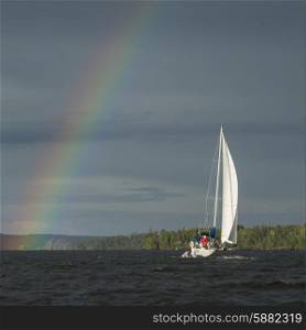Rainbow over a lake with a sailboat, Lake Of The Woods, Ontario, Canada