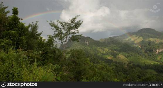 Rainbow over a mountain range, Thailand