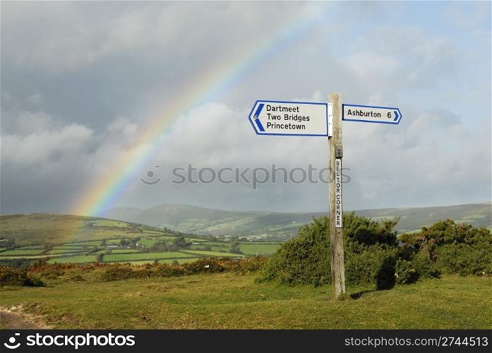 Rainbow over a signpost on dartmoor, Devon, UK.