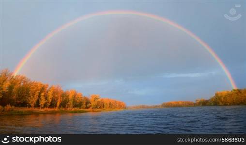 Rainbow over the river in fall