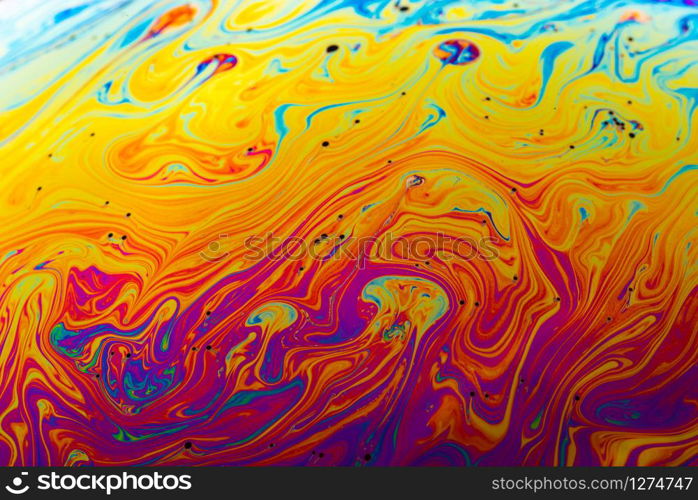 Rainbow soap bubble on a dark background. Close-up of colorful surface.. Abstract background made from soap bubble reflecting light