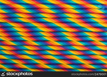 Rainbow vibrant multicolored striped paper straws background