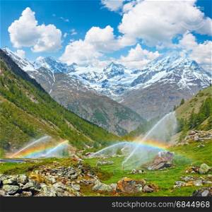 Rainbows in irrigation water spouts in Summer Alps mountain (Switzerland, near Zermatt). Two shots stitch image.