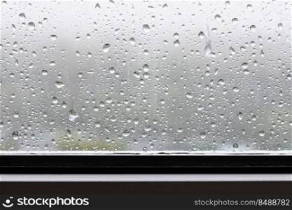 raindrops and trickles of rain close up on window in heavy rain