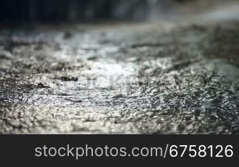 Raindrops are broken with splashes falling on the asphalt