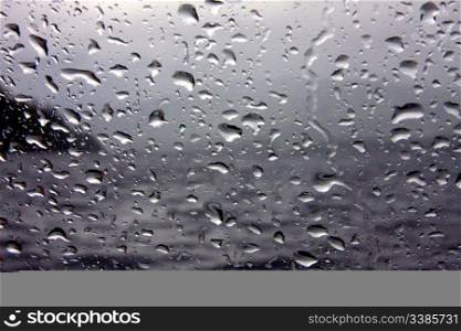 Raindrops on a Glass Pane Against a Dark Sky