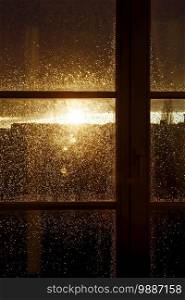 raindrops on a window pane at sunset 