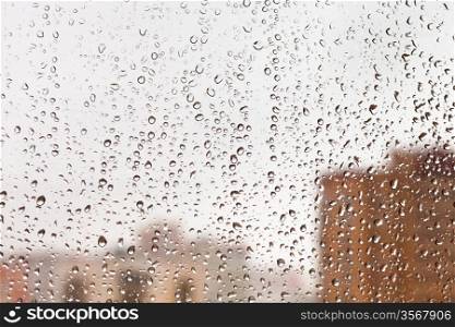 raindrops on glass window with cityscape background