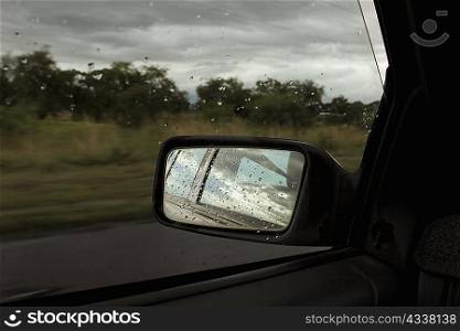 Raindrops on side mirror of car