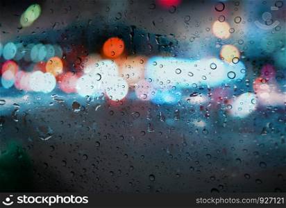 Raindrops with light bokeh on the road rain season background