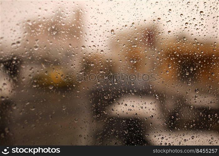 Rainy city background. Raindrops on window glass on autumn day. Wet home window with raindrops. High quality photo.. Rainy city background. Raindrops on window glass on autumn day. Wet home window with raindrops. High quality photo
