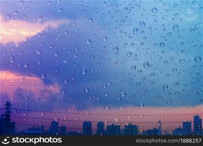 Rainy Day in City during Twilight. focused on Droplet. Water Texture Background, Rain Drops on Glass Window