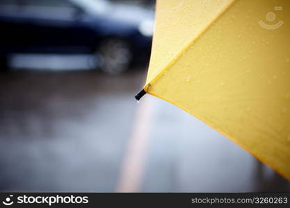 rainy walk with yellow umbrella, selective focus on part with drop