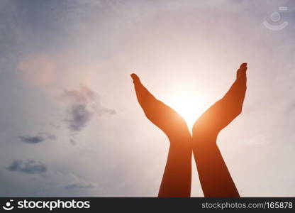 Raised hands catching sun on sunset sky. Concept of spirituality, wellbeing, positive energy etc.. Raised hands catching sun on sunset sky. Concept of spirituality, wellbeing, positive energy