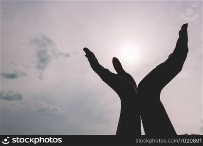 Raised hands reaching to the sky. Concept of spirituality, wellbeing, positive energy. Raised hands reaching to the sky.