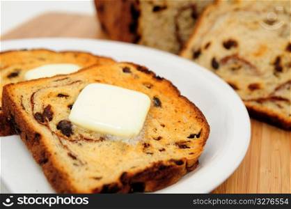 Raisin Cinnamon Toast. Raisin bread toast with melting butter on top ready to be spread