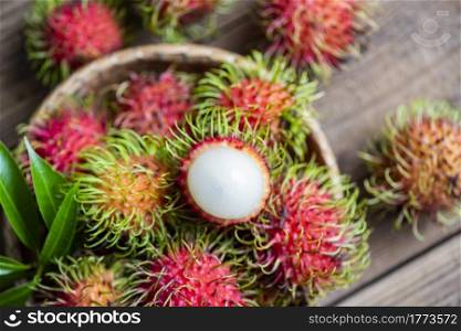 Rambutan fruit on basket and wooden background harvest from the garden, Fresh and ripe rambutan sweet tropical fruit peeled rambutan with leaves