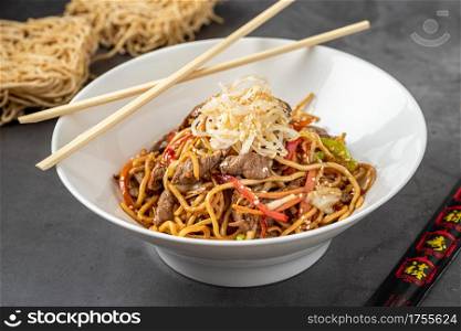 Ramen asian noodle in broth with Beef on stone background