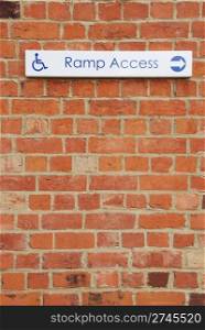 ramp access sign on a brick wall background