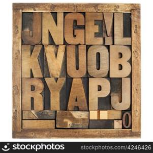 random letters of alphabet and punctuation symbols - vintage letterpress wood type blocks in rustic box isolated on white