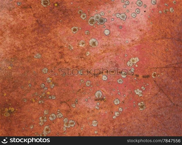 Random patterns of red paint, rust, and lichen on an old abandoned truck result in an abstract, grungy kind of background.
