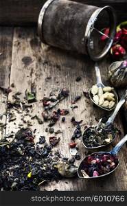 range of tea leaves. Three teaspoons of brew different varieties on the background of the straine
