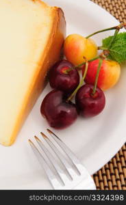 Ranier and Bing cherry on a white plate withe a slice of plain cheese cake.. Cherries And Cheese Cake