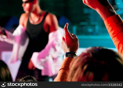 Rap or Hip-Hop Musicians performing on stage in a club in front of a cheering crowd