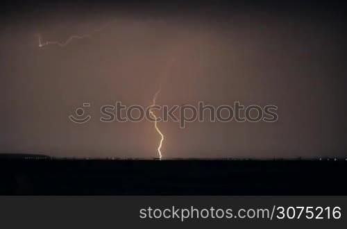 Rapid lightnings strikes in the sky during thunderstorm over the city at night