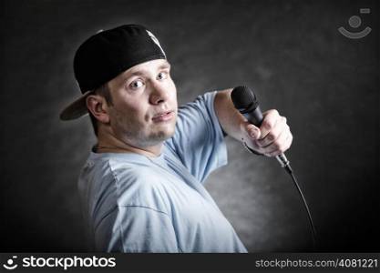 Rapper attitude rap singer hip Hop Dancer performing. Young man with microphone singing black grunge background
