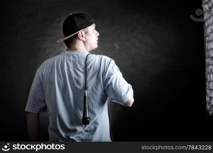 Rapper attitude rap singer hip Hop Dancer performing. Young man with cap microphone back view black grunge background