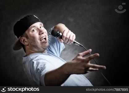 Rapper attitude rap singer hip Hop Dancer performing. Young man with microphone singing hand cool gesture black grunge background