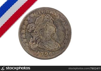 Rare United States of America coin with ribbon colors isolated on white background in horizontal layout with ribbon in upper left hand corner. Coin rim damaged in some locations.