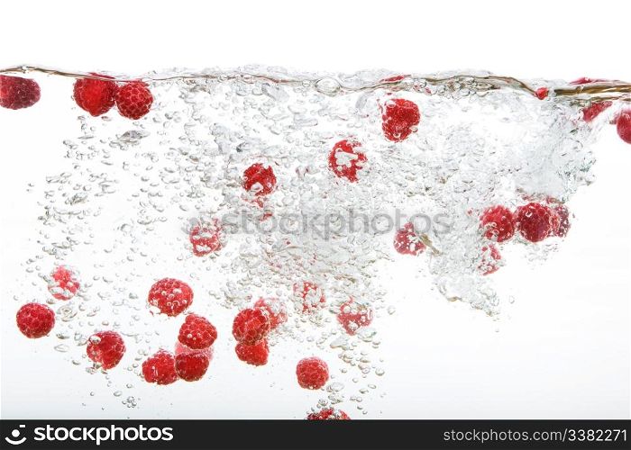 Raspberries floating in water with bubbles and waves