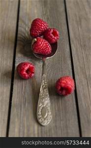 Raspberries in rustic setting with wooden background