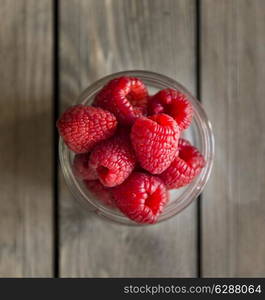 Raspberries in rustic setting with wooden background