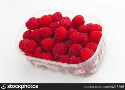 Raspberries in the plastic case, white background.