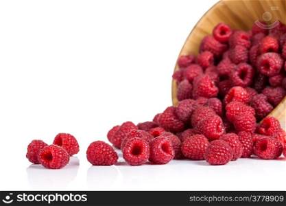 Raspberries in wooden bowl on white background