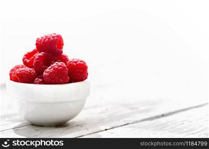 raspberries on little bowl with on white background