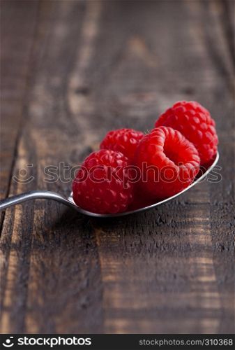 Raspberries on old spoon on grunge wooden board. Natural healthy food. Still life photography