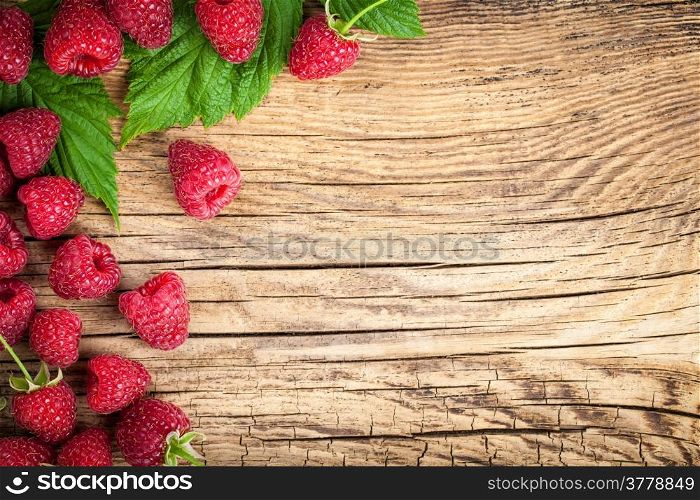 Raspberries on wooden table background. Copy space. Top view